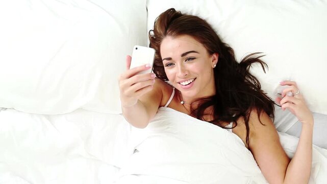 Above, video call or woman in bed with phone, comfortable or communication on dating site. Happy, conversation or female person in house with tech, online chat or connection on matchmaking platform.