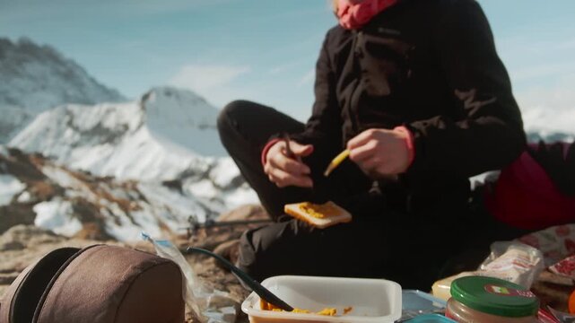 Hiker rests on snowy peak in Switzerland, enjoying mountain view