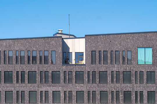 Minimal exterior geometric pattern on brick windows of modern facade architecture building creating clean repetitive design against blue sky