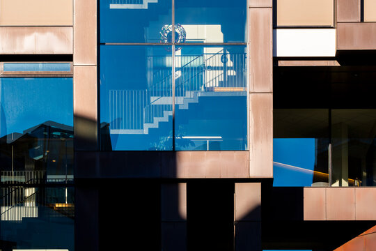 Modern facade architecture building with abstract geometric pattern of glass panels and reflection forming a bold exterior composition for creatives