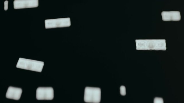 Rain of US dollar banknotes on a dark background