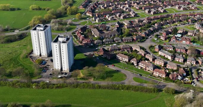 Aerial view of Seacroft Leeds West Yorkshire showing housing estate tower blocks open green fields and winding roads with suburban neighbourhood layout captured from above in the spring time