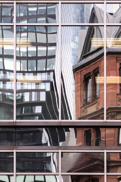 Glass facade reflections frame modern architecture beside historic brickwork creating contrast in Frankfurt Bankenviertel Germany financial streets