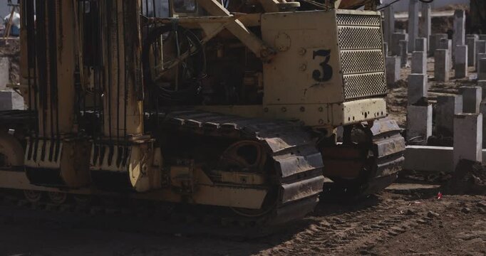 Tracked pile driving machine on construction site