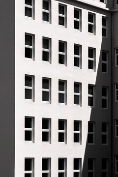High contrast exterior architecture showing modern facade windows with symmetry geometry pattern and graphic contrast on a tall building