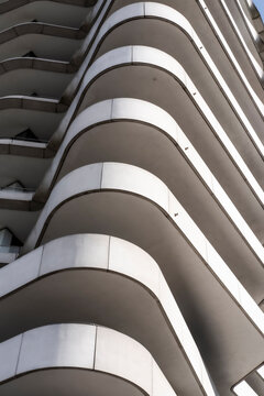 Curved exterior architecture featuring modern apartments facade with balconies geometry pattern and flowing curves shaping a bold design