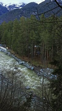 A wide mountain river on a cloudy day. A bird's eye view of a spring forest.