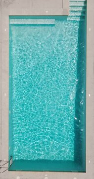 Blue water in the swimming pool with light reflections.