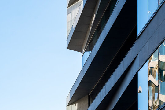 Abstract modern architecture facade of a building with diagonal lines and reflections under clear sky creating minimal geometric design detail