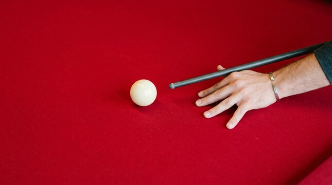 Close-up of a pool player preparing to hit the cue ball on a red felt pool table utilizing precise aiming for a strategic billiards shot