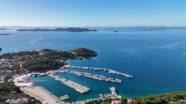 Circular drone flight above Drage marina near Pako&scaron;tane, showing many surrounding islands, the village and coastal road, ending with a view of Vrana Lake and the hill behind.
