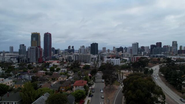 Cinematic drone pullback revealing the San Diego skyline at 7PM during dusk. Soft evening light transitions into city glow as buildings and skyline come into view.