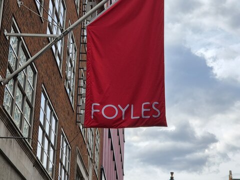 London UK 03.07.2025 Foyles bookstore red flag sign mounted on building facade in city street representing iconic literary retail brand and urban architecture