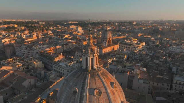 Drone Flying By Chiesa di Sant'Agnese in Agone church Dome at sunset in Rome, Italy, towards Altare della Patria, Vittoriano Terracotta-roofed Houses In golden hour. panning Aerial shot