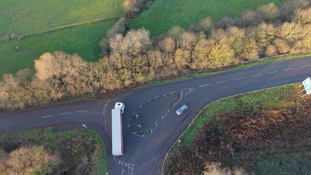 Aerial View Articulated Lorry Making Turn, Narrow Country Lane Flanked By Trees, Lone Car Passing, Autumn Tones, Driver Delivering Freight With Careful Steering Through Rural Junction