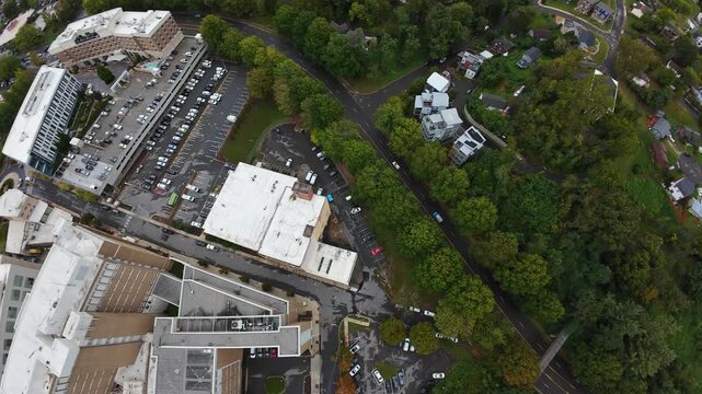 Aerial Asheville Neighborhood Parking Lot View, Curved Road Flanked By Dense Trees And Scattered Houses, Overcast Light, Slow Traffic, Planning Perspective For Local Infrastructure