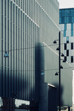 Industrial modern architecture facade with lamps and windows casting shadows as geometry lines reveal texture for abstract background design