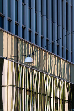 Modern architecture facade cladding with vertical stripes and texture plus a lamp highlighting geometry pattern for clean abstract background
