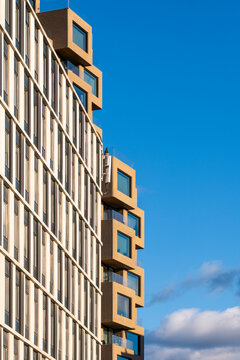 Detailed modern architecture facade of a highrise with vertical windows forming geometry pattern minimalism against bright sky background