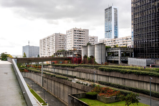 Urban canal beside street road in Paris La Defense with skyline of office skyscraper architecture reflecting on water and framing a quiet route