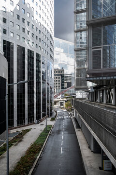 Urban corridor street road in Paris La Defense framed by office skyscraper architecture with deep perspective and layered modern structures in daylight