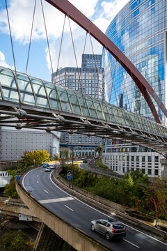 Street road and bridge create modern urban perspective between skyscraper office architecture in Paris La Defense with glass towers and open sky