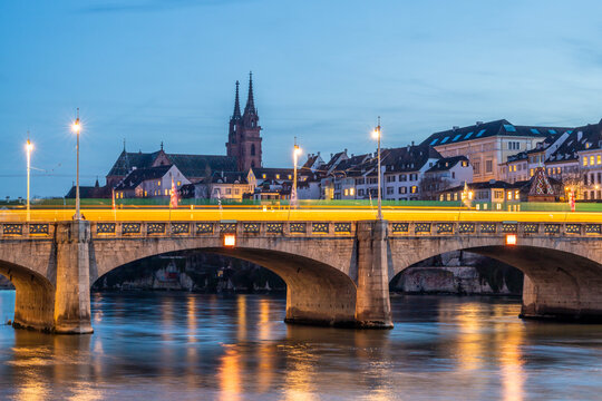 Tram crossing bridge over Rhine with Baseler M�nster in Basel at evening