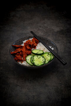 Vegan sweet chili beef substitute with rice and cucumber salad in bowl