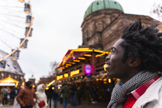 Smiling man exploring winter christmas market at night