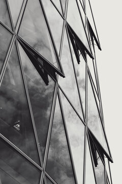 Modern monochrome abstract architecture of a glass facade building where diagonal pattern meets reflection creating a bold graphic design detail