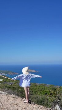 Asian woman enjoying summer vacation at the beach, wearing sun hat and sunglasses, smiling with blue ocean background