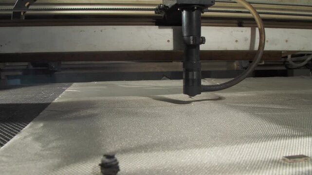 Laser knife slices through radio signal-blocking fabric. Each cut ensures Faraday cloth maintaining integrity for mobile device protection