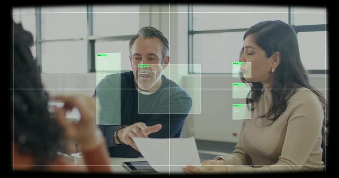 Pointing man dark-shirt and woman beige-shirt scanning printed document at meeting table, green HUD