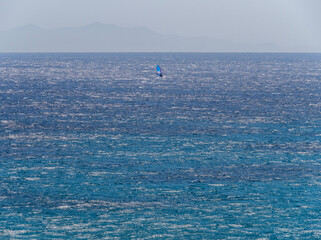 Naklejka premium Windsurfer sailing in the Aegean Sea on the island of Mykonos, Greece.