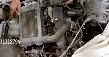 Fototapeta premium Inspecting engine block with corrugated intake hose and white cloth in garage, with bare forearm
