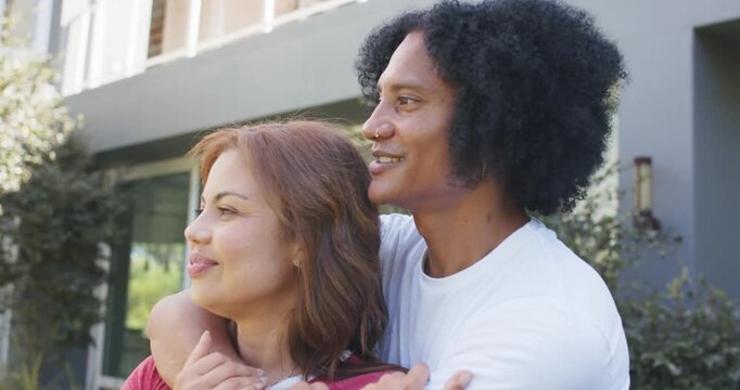 African American couple hugging outside home man wrapping arms leaning laughing showing love watch