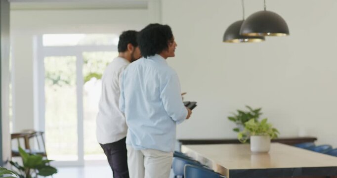 African American guides entering dining area leading tour pointing at pendant lights showing layout