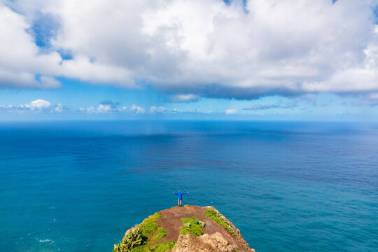 Tourist standing at Miradouro da Garganta Funda overlooking ocean in Madeira