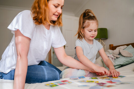 Mother and child playing educational board game together at home