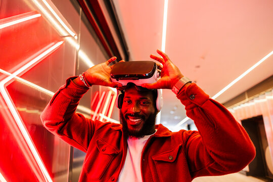Smiling man with VR headset enjoying immersive virtual experience indoors