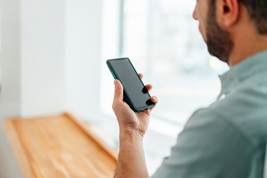 Self-employed developer using smartphone with copy space indoors