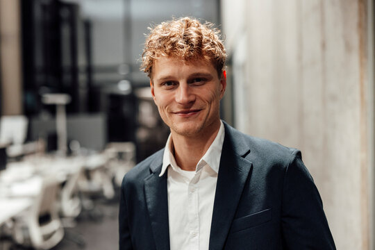 Businessman smiling at modern office in suit