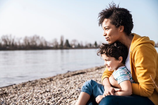 Family enjoying leisure time by the river on a sunny outdoor day