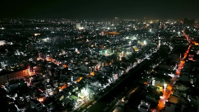 Stunning aerial drone shot of fireworks exploding over an Asian city during New Year's Eve. Vibrant night lights and urban density in Vietnam. Perfect for travel and festive themes