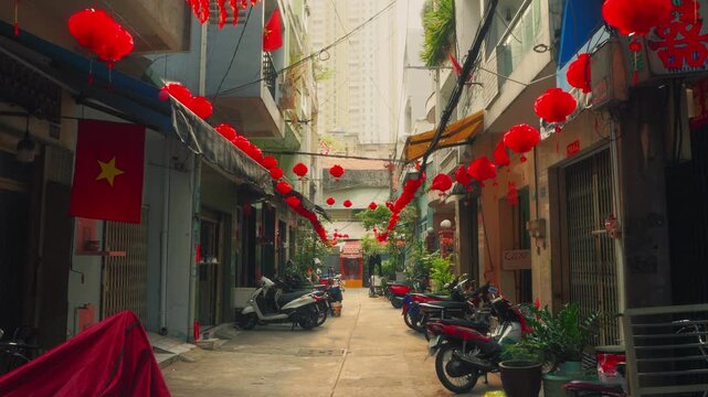 Narrow alley in Saigon's Chinatown featuring red lanterns and Vietnam flags. Capture the authentic local life, motorbikes, and culture of Cho Lon in District 5, Ho Chi City