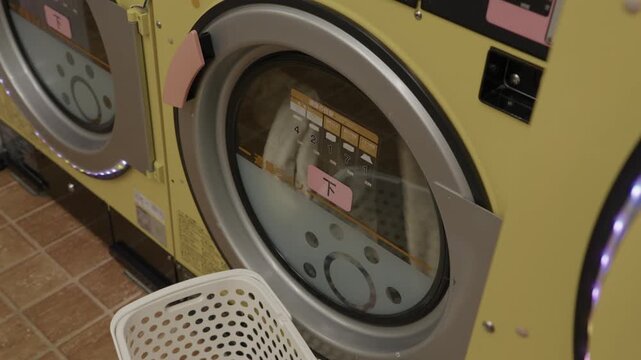 Yellow coin laundromat washing machines with laundry basket and kanji label, Japan
