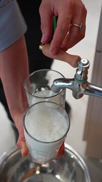 Vertical Shot of Traditional Foamy Ayran Being Poured from Fountain into Glasses, Yogurt Drink