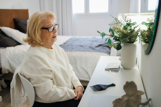 Smiling adult relaxing in bedroom reading at desk in the morning
