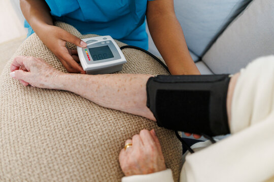 Nurse measuring blood pressure at home during a healthcare checkup