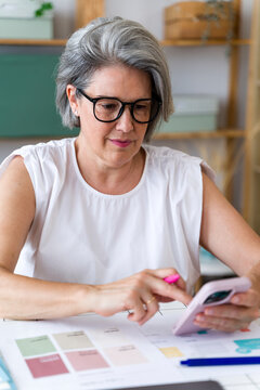 Businesswoman planning strategy with notes and smartphone at office desk